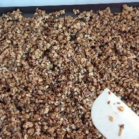 Granola been spread on a non-stick tray