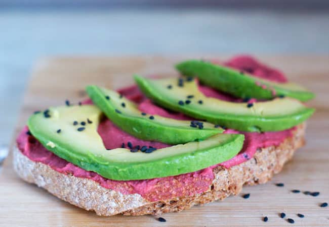 Beetroot hummus on bread with avocado