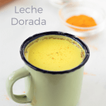 Una taza verde con leche dorada adentro