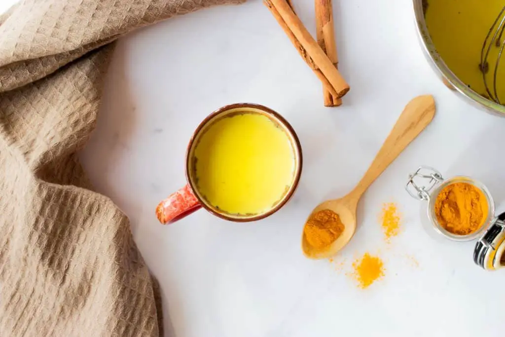 A mug with a yellow beverage called golden milk