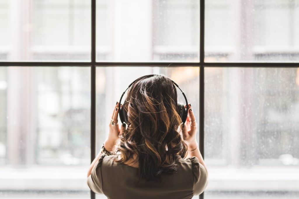 A woman with headset listening to positive affirmations