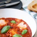 A close up of a pan with eggs in Purgatory, eggs in a tomato sauce