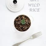 Black rice in a small pot, a lid, a fork and the sentence "Everything about wild rice"