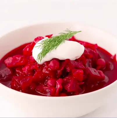 Borscht served in a bowl with sour cream and fresh dill