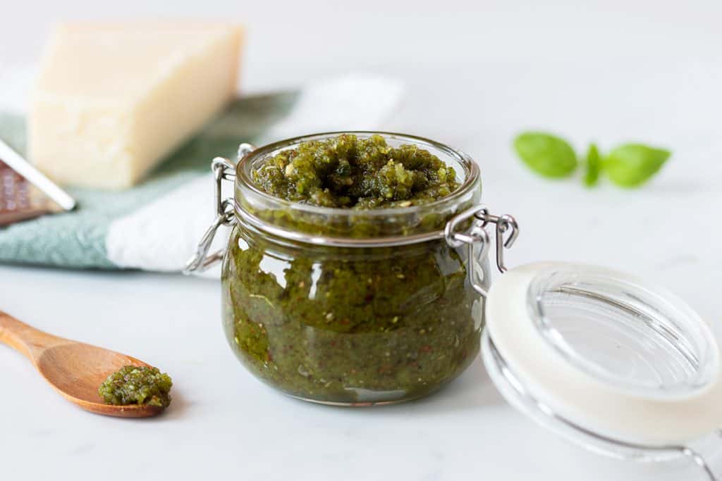 A jar with green pesto inside