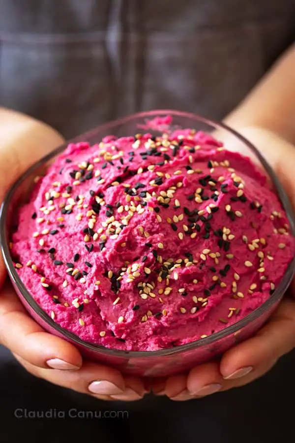 Beetroot And Chickpea Hummus hold by two hands